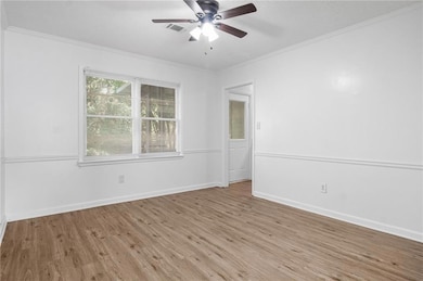 Unfurnished room with crown molding, wood finished floors, and ceiling fan