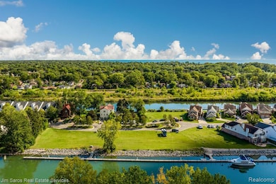 Aerial view of residential area with a nearby body of water and a tree filled landscape