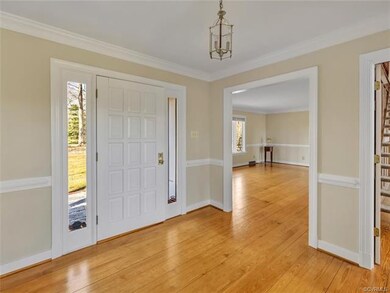 The foyer has wood floors, chair rail, and crown m