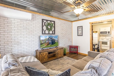 Living room featuring brick wall, wood-type floori