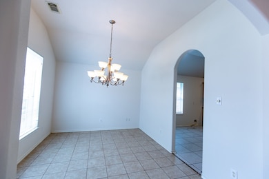 The dining area with tile flooring and an arched e