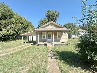View of front facade with a front lawn and covered