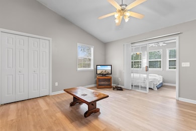 Sitting room featuring vaulted ceiling, ceiling fa