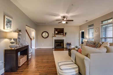 The family room features a gas fireplace, neutral colors, and wide-plank hardwood floors.