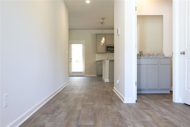 Hall featuring baseboards and a sink