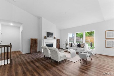 Living area with high vaulted ceiling, dark wood-style flooring, and a glass covered fireplace