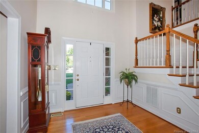 Two Story Foyer With Hardwood Floors.