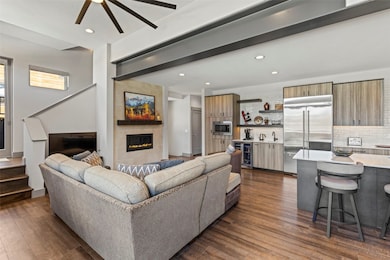 Living area with bar, ceiling fan and a tiled fire
