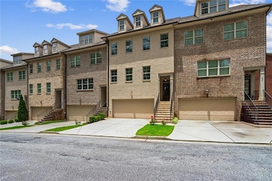 Townhome / multi-family property featuring stairs, brick siding, an attached garage, and concrete driveway