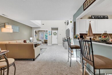 Living room with light colored carpet, visible ven