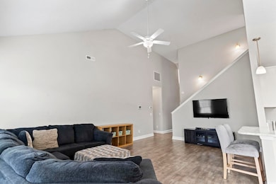 Living area with a ceiling fan, high vaulted ceili