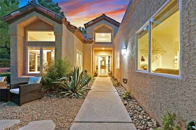 Exterior entry at dusk with stucco siding and a ti