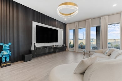 This modern living room features a sleek black accent wall, contemporary chandelier, combining comfort with a chic aesthetic