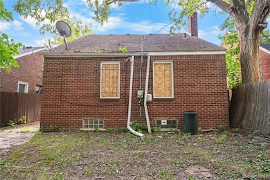 Rear view of house featuring a chimney, brick siding, and roof with shingles
