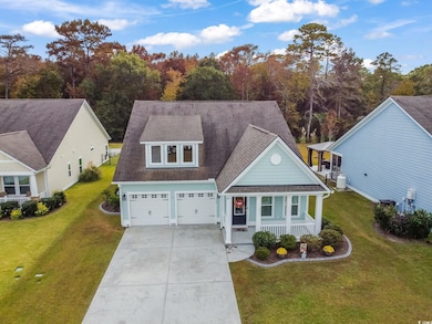 View of front of property with roof with shingles, covered porch, and a front yard