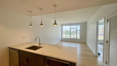 Kitchen featuring a peninsula, light wood-style flooring, hanging light fixtures, light stone counters, and dishwasher