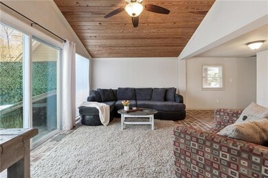 Living room featuring wood ceiling, a ceiling fan,