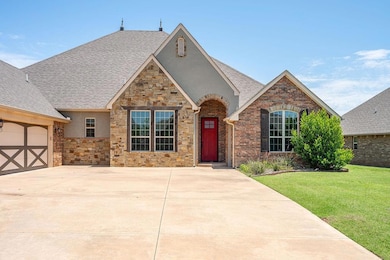 View of front of house with stucco siding, stone siding, a front lawn, and roof with shingles