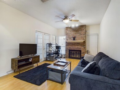 Living area featuring a brick fireplace, wood fin