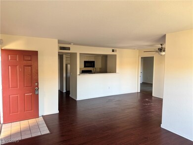 Unfurnished living room featuring dark wood-type flooring and a ceiling fan