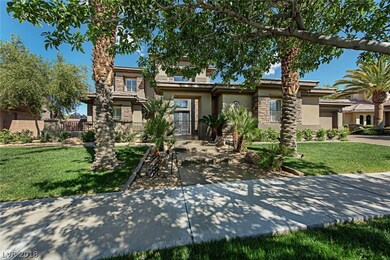 Front yard has lush landscaping and mature palm tr