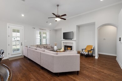 Living room featuring lofted ceiling, ceiling fan,