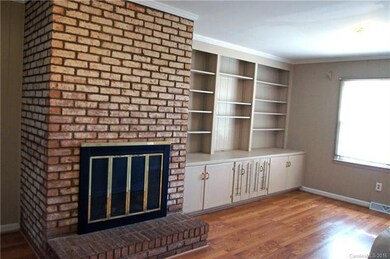 Den has a fireplace and plenty of book shelves.