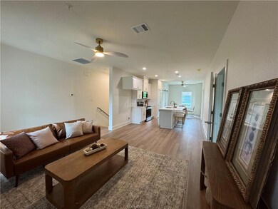 Living room with ceiling fan, light wood-style flo