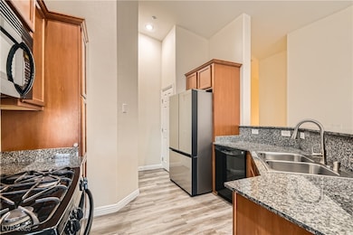Kitchen with black appliances, a sink, brown cabin