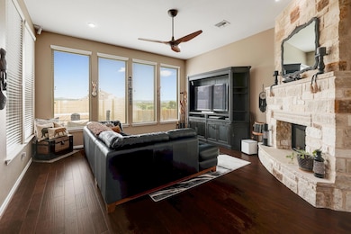 Living room with ceiling fan, a fireplace, plenty