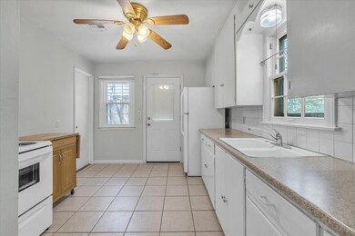 Kitchen with backsplash, white appliances, sink, a