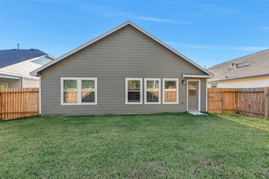 The back of the home features a spacious yard that