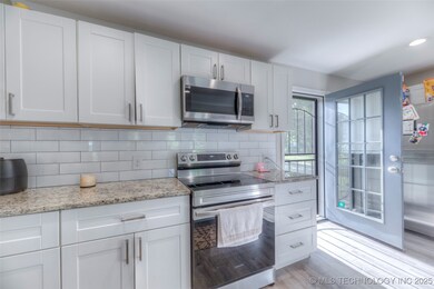 Kitchen with stainless steel appliances, light woo