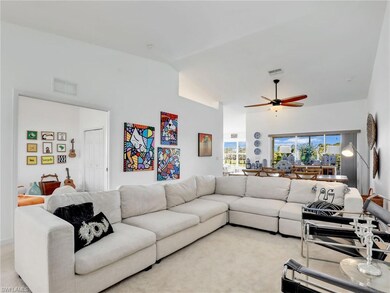 Carpeted living room with ceiling fan and vaulted 