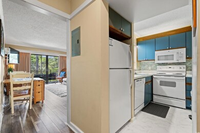 Kitchen with white appliances, a textured ceiling, backsplash, light countertops, and a sink