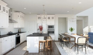 Kitchen with island, pendant lighting and glass upper cabinets