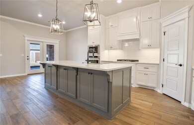 Kitchen with a kitchen island with sink, gray cabi
