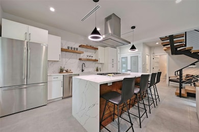 Kitchen with island range hood, a sink, white cab