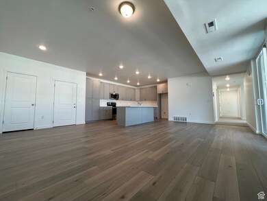 Unfurnished living room featuring hardwood / wood-style flooring and sink