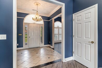 Entryway featuring crown molding, an inviting chan