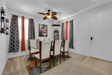 Carpeted dining room with ceiling fan