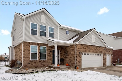 Traditional home featuring brick siding, driveway, and a garage