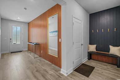 Mudroom featuring wood finished floors, wooden walls, and baseboards