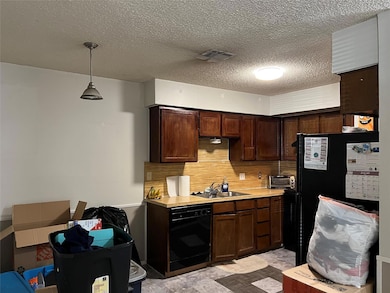 Kitchen featuring pendant lighting, sink, backspla