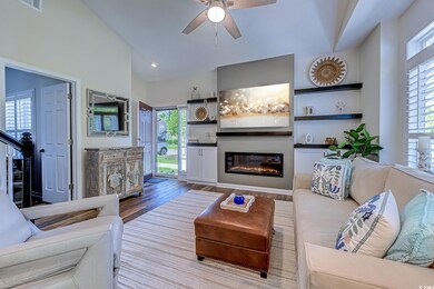 Living room with ceiling fan, a glass covered fire