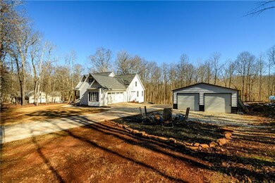 View of side of home with an outdoor structure and a garage