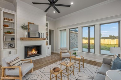 Living room with a large fireplace, ceiling fan, c