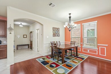 An additional view of the Dedicated Dining Room that also features wonderful wood flooring, chair railing, and adjacent Elegant Entryway and Gourmet Kitchen.