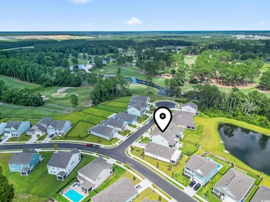 Aerial view of property and surrounding area with a nearby body of water and nearby suburban area