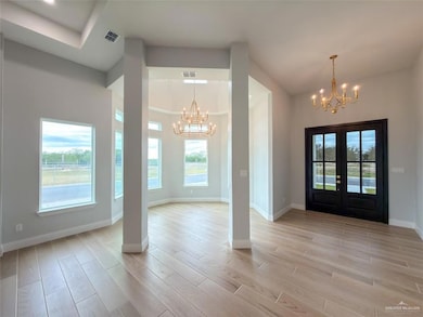 Entrance foyer featuring a chandelier, wood finish floors, and french doors